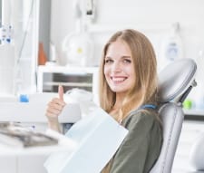 девушка сидит в кресле у ортодонта